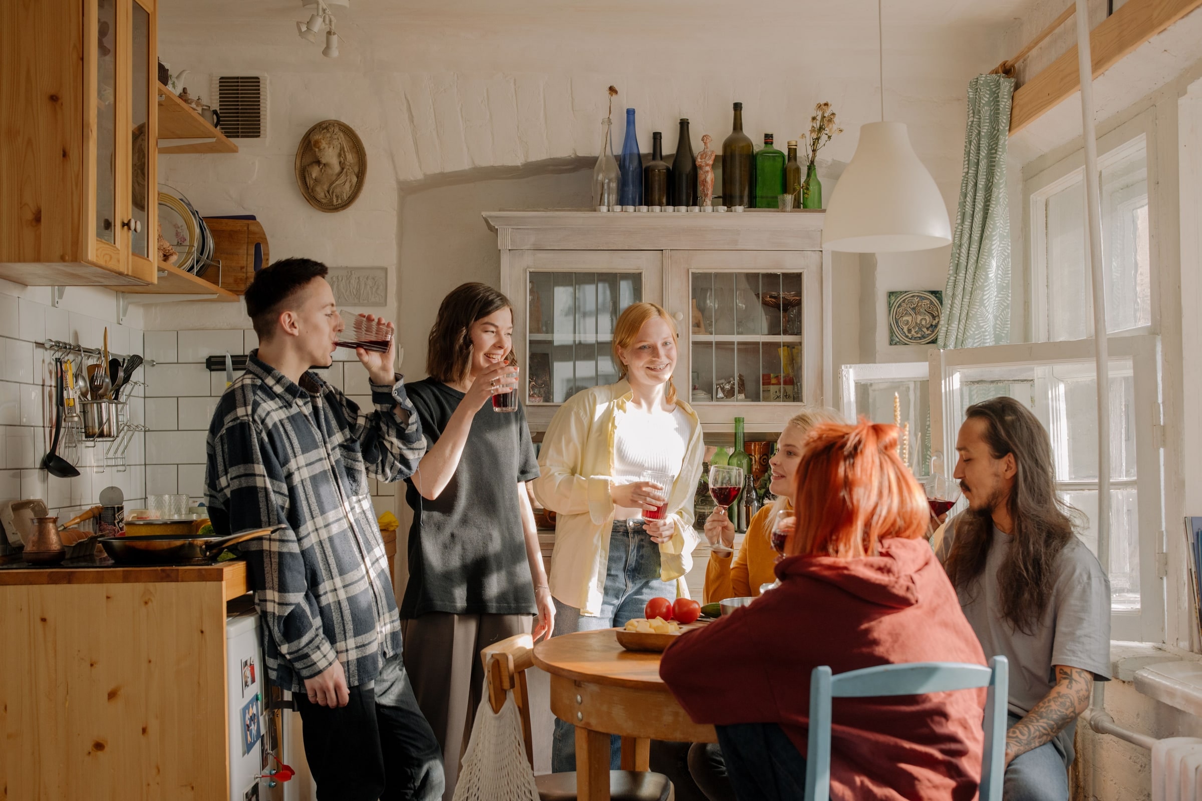 Un groupe d'amis cuisine et trinque ensemble dans une cuisine lumineuse