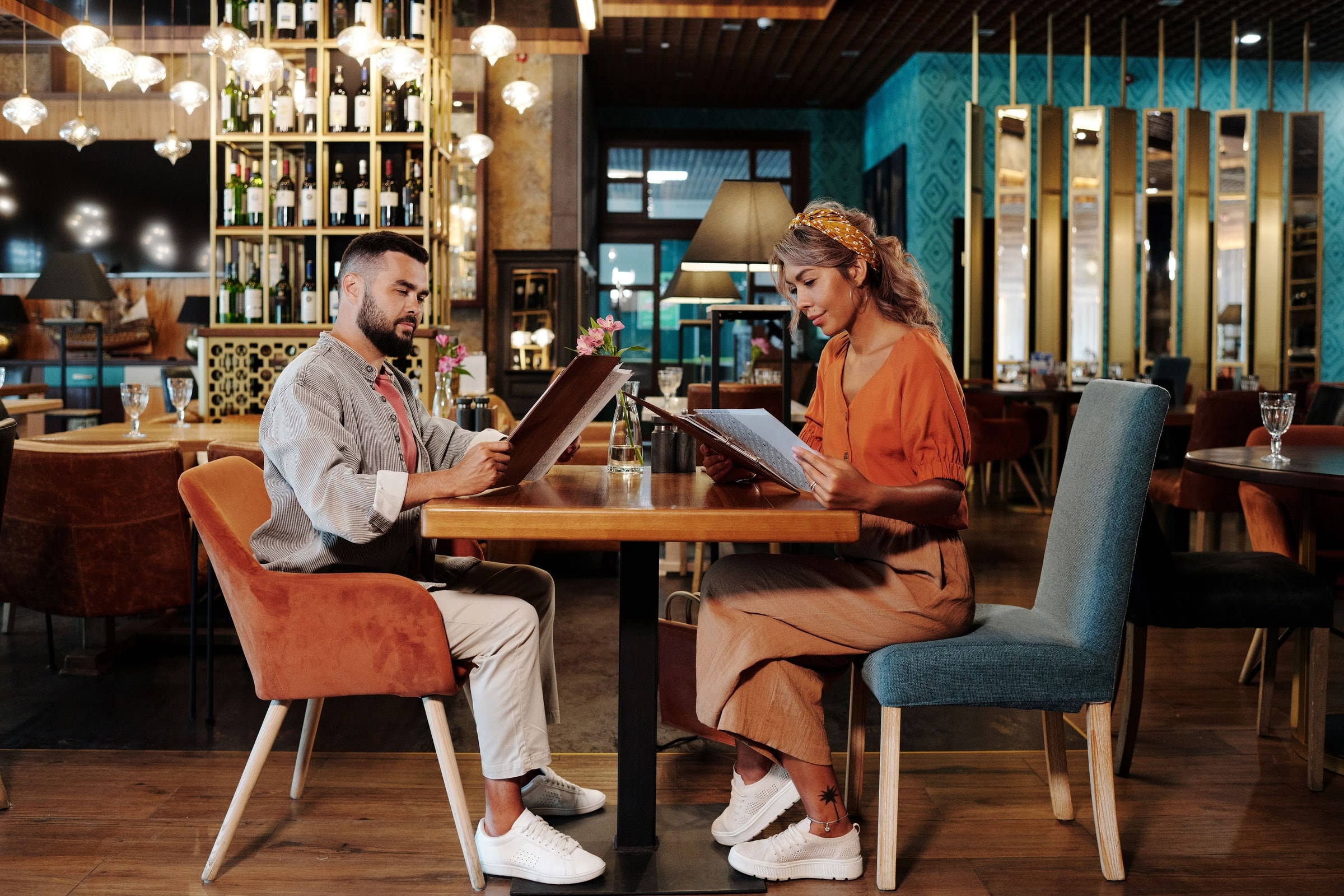 Un couple attablé au restaurant consulte le menu ensemble